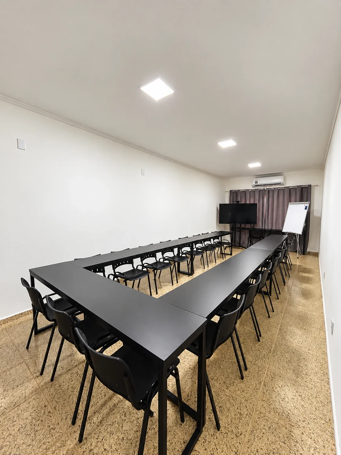 Sala 7 da Unidade 2 com mesas em U para reunião e workshop